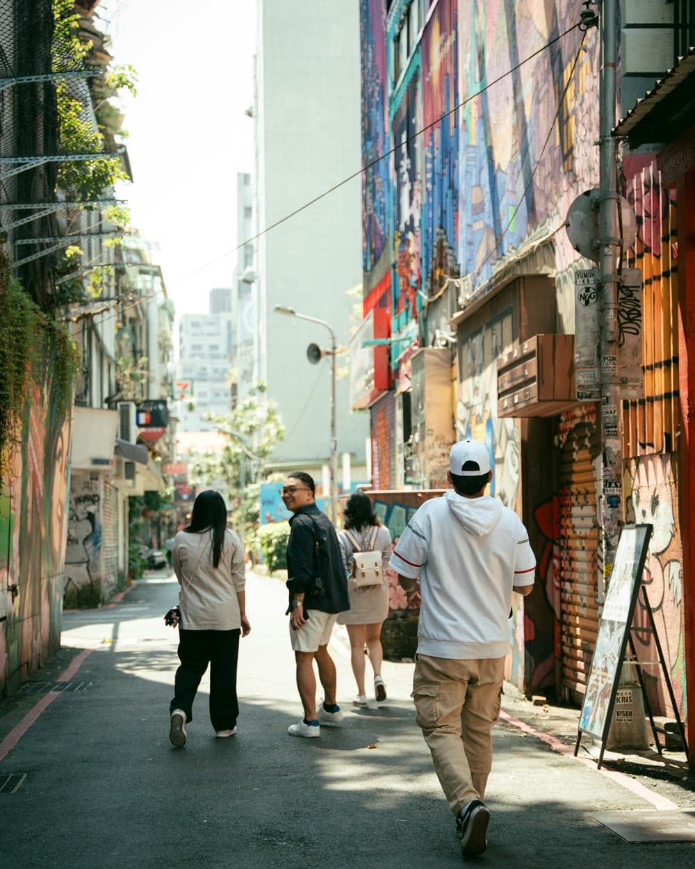 A traveler walking through a sunlit city street, headphones on, listening to an audio tour.